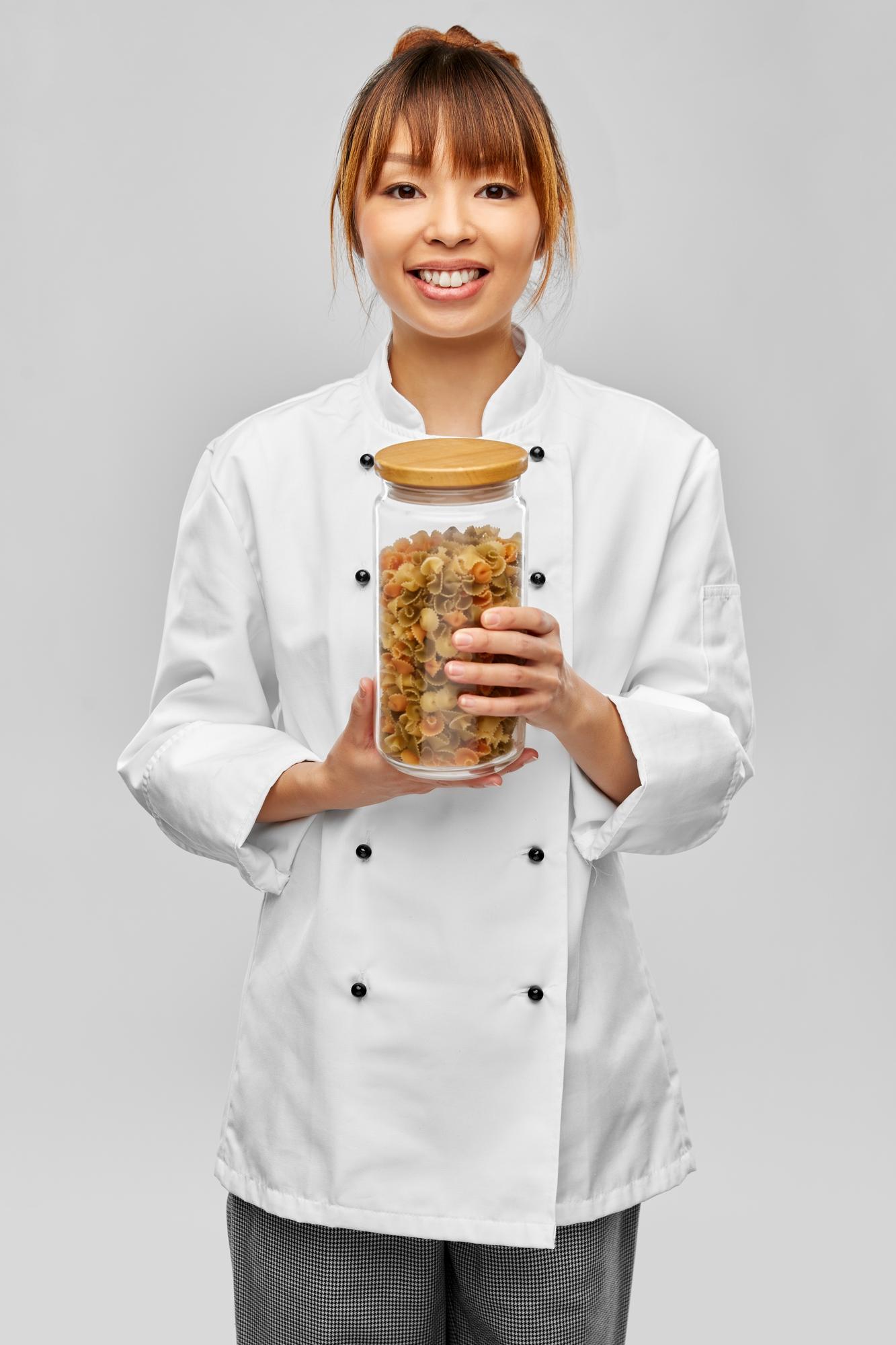 staff member holding a completed meal kit in a bright kitchen