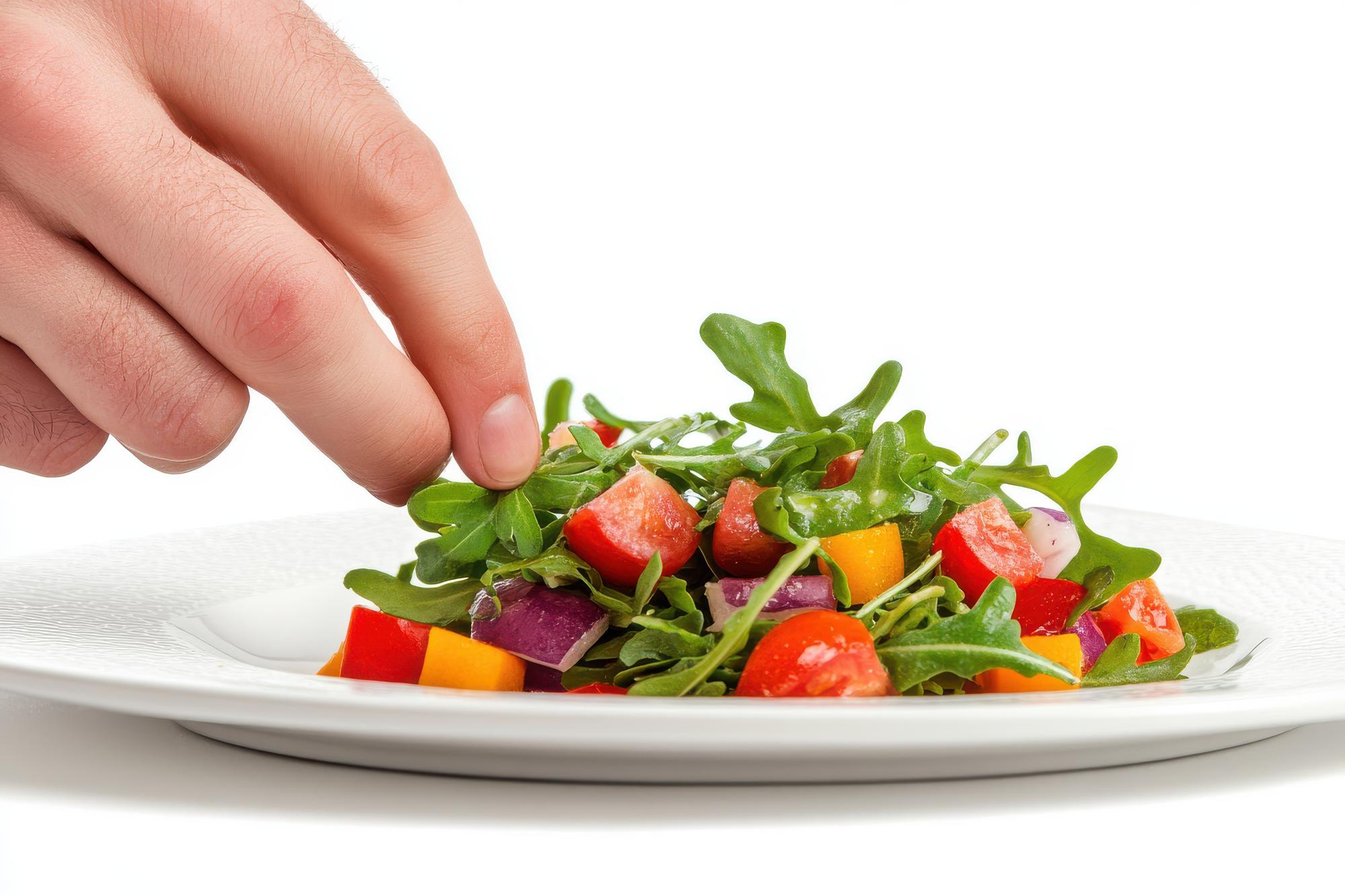 hands plating a simple composed salad